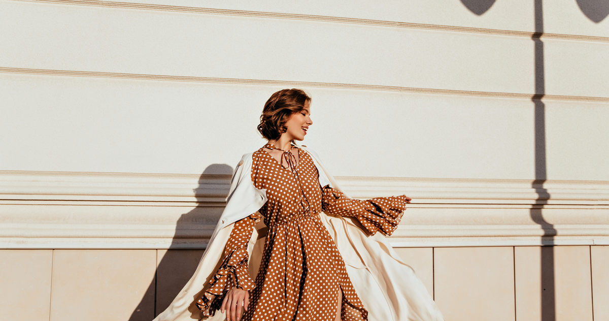 Woman wearing a flowing patterned dress with a light layer