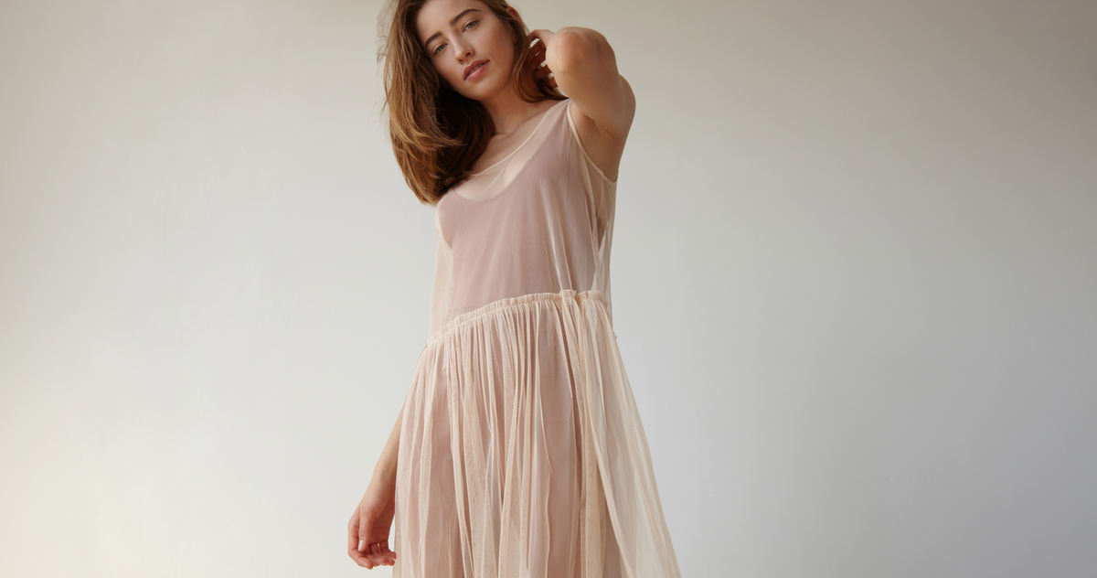 Woman wearing a soft flowing dress in a studio setting