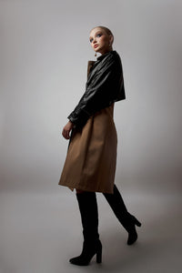 Model wearing a sculpted layered ensemble with a cropped jacket and midi-length skirt