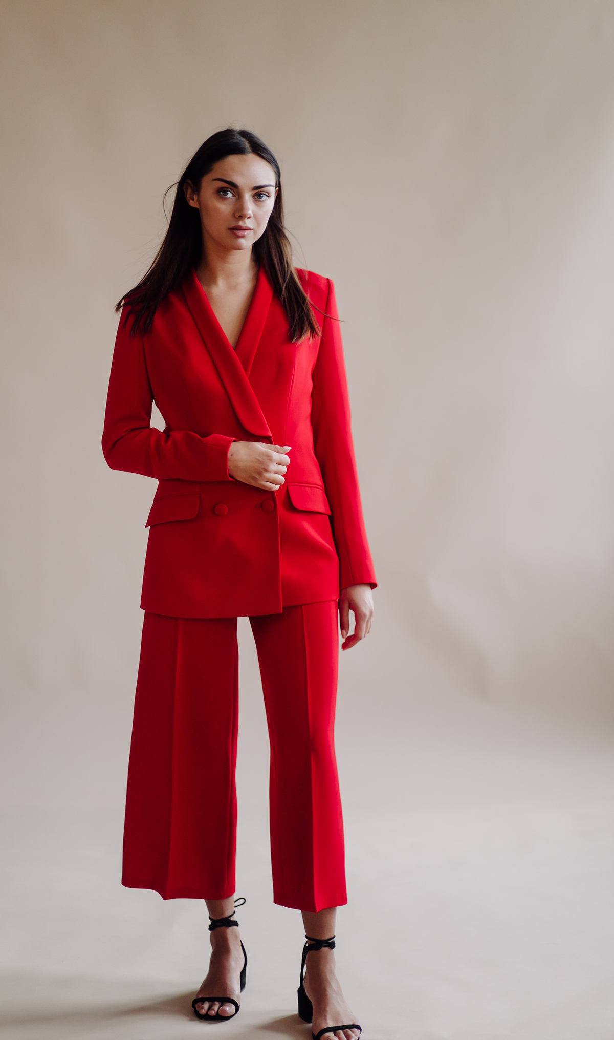 Model wearing a polished tailored suit with a wrap-inspired blazer and cropped trousers