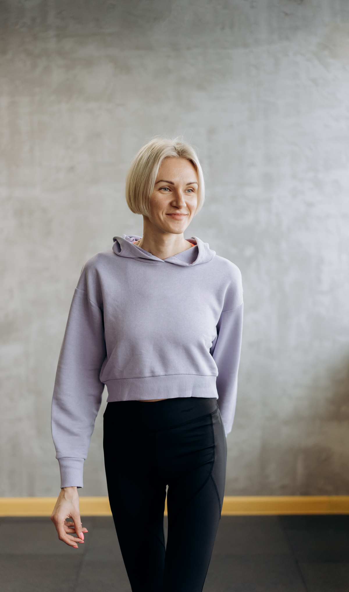 Model wearing a cropped everyday hoodie with an adjustable hood and relaxed silhouette