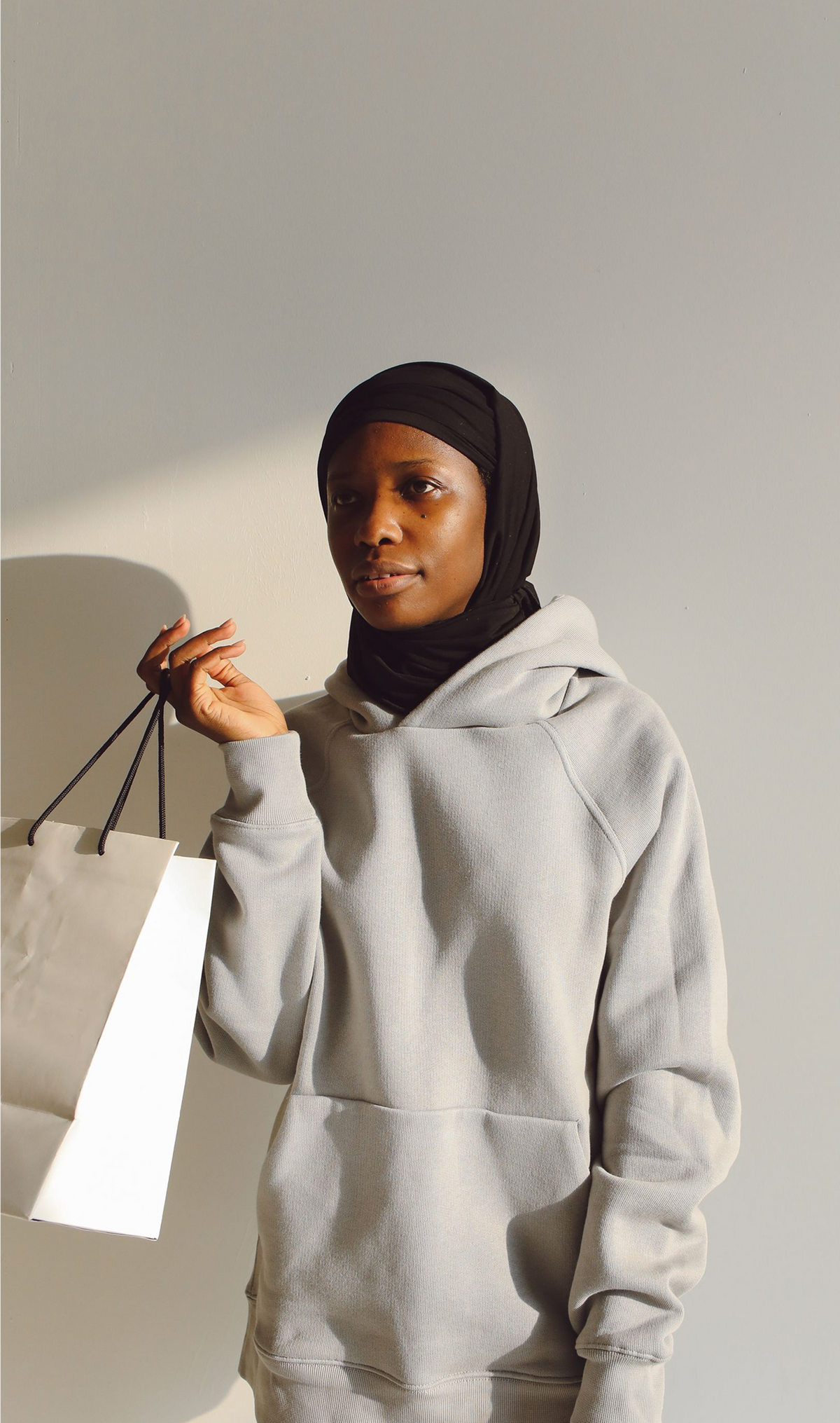 Model wearing a refined comfort hoodie with a clean pullover shape and structured hood