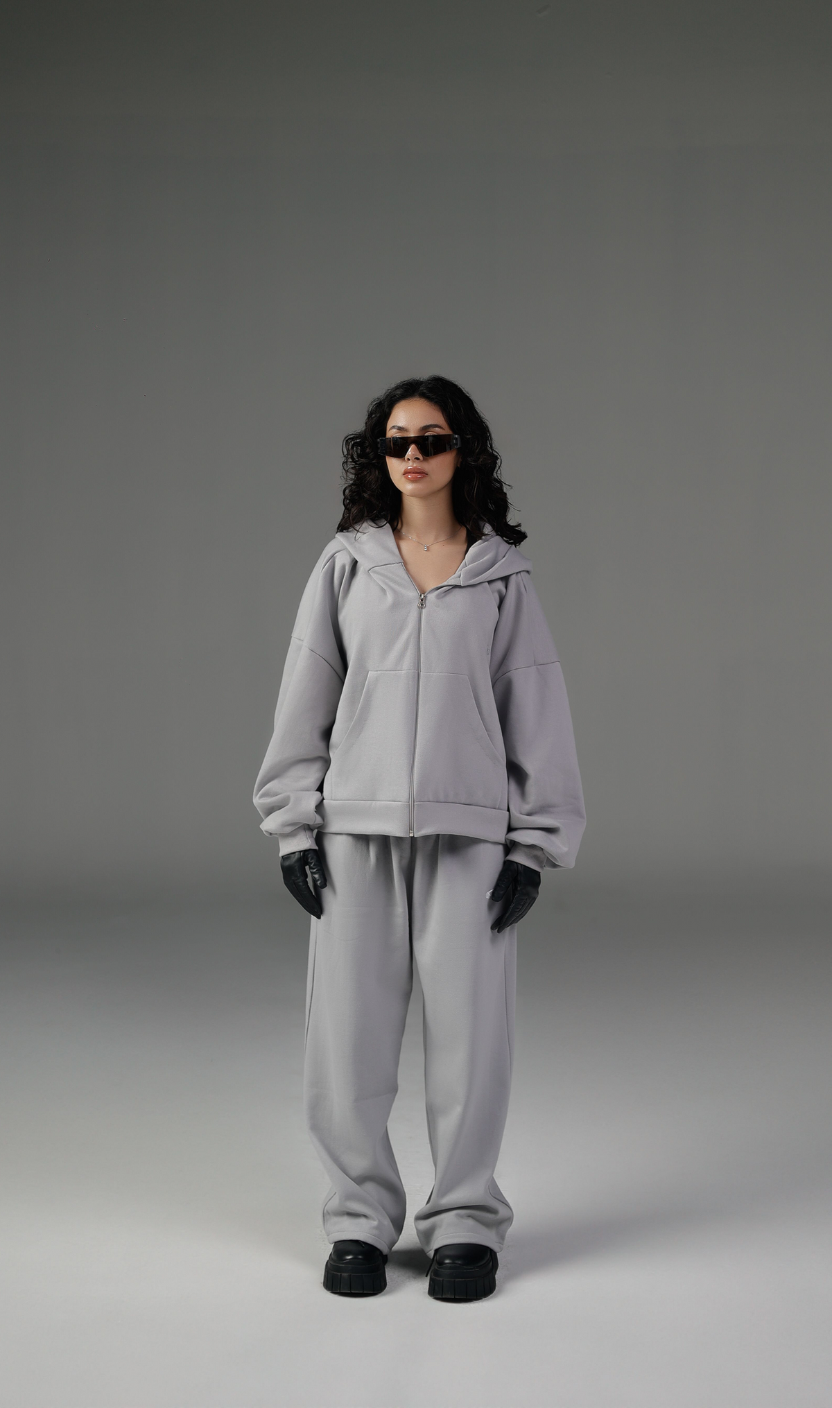 Model wearing a lounge zip set with a full-zip hooded jacket and relaxed trousers