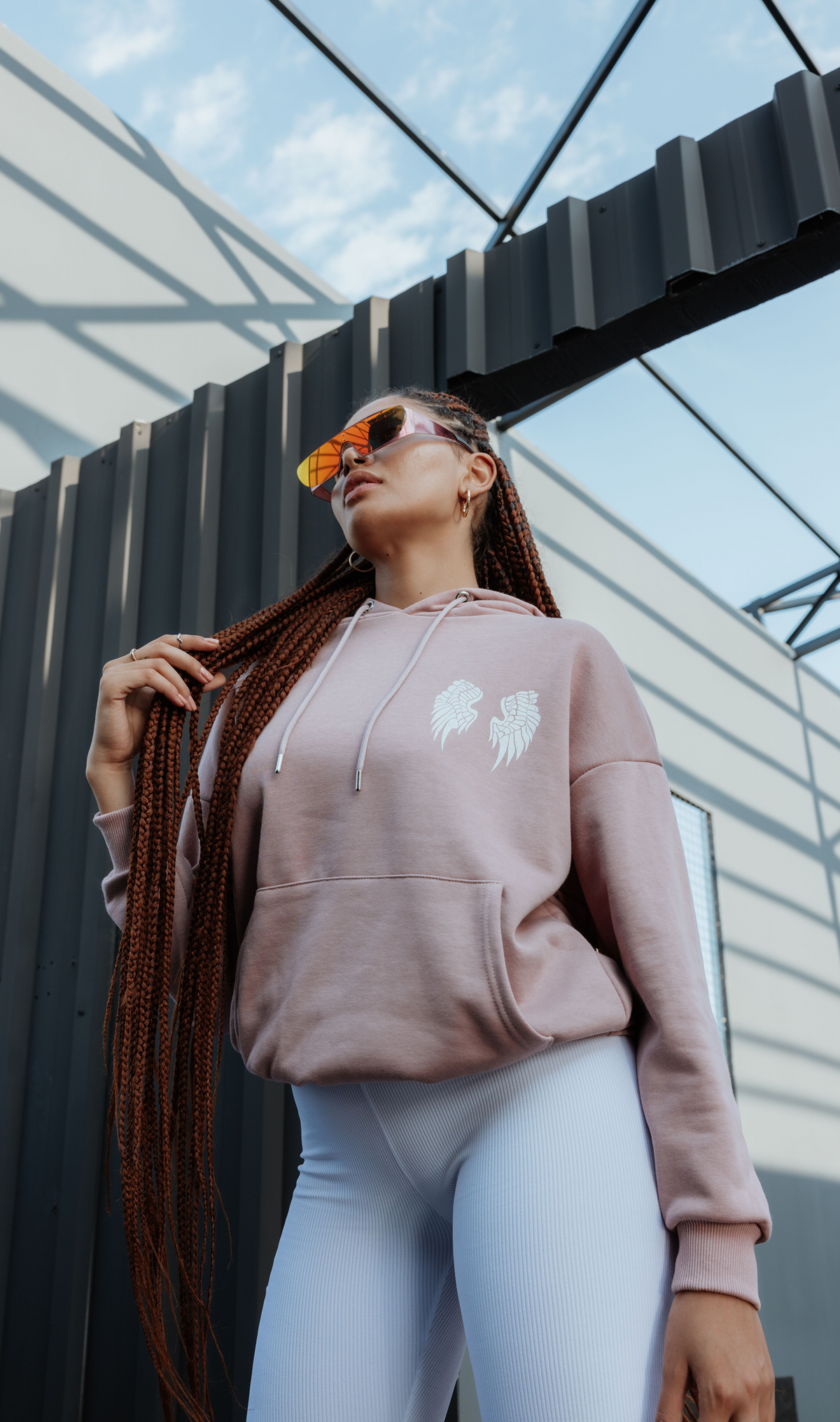 Model wearing a relaxed graphic hoodie with a drawstring hood and chest motif