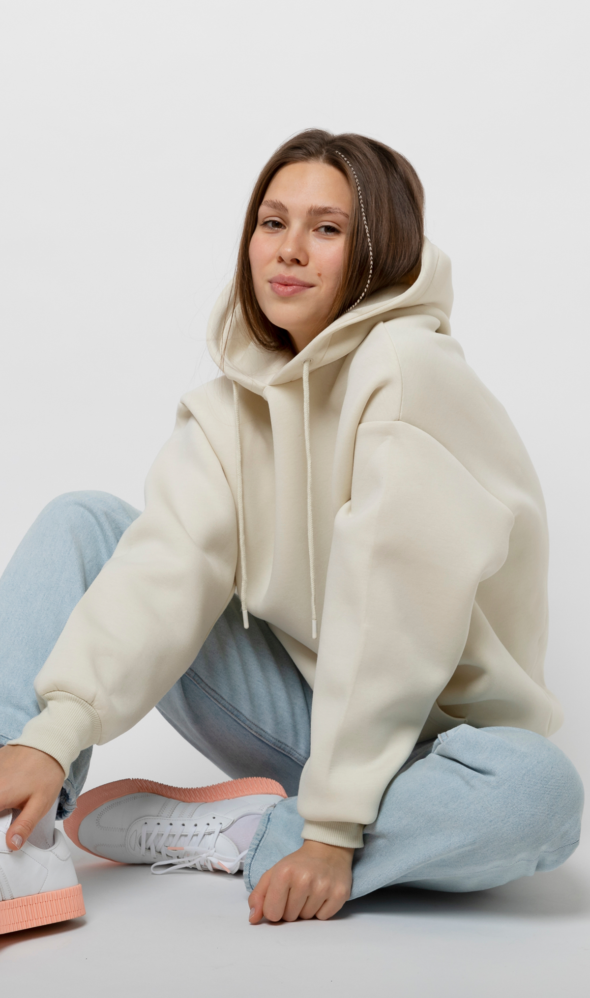 Model wearing a cropped fleece hoodie with a drawstring hood