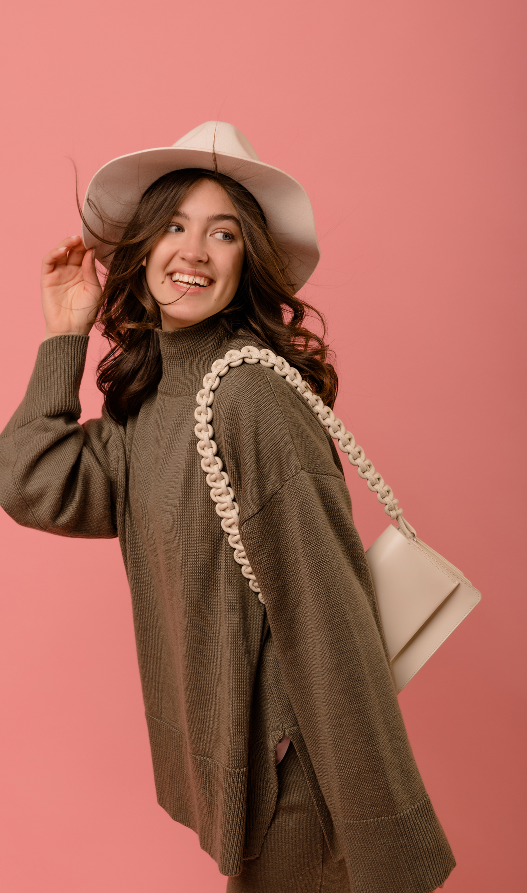 Model wearing a relaxed ribbed sweater with a high neckline and side slits