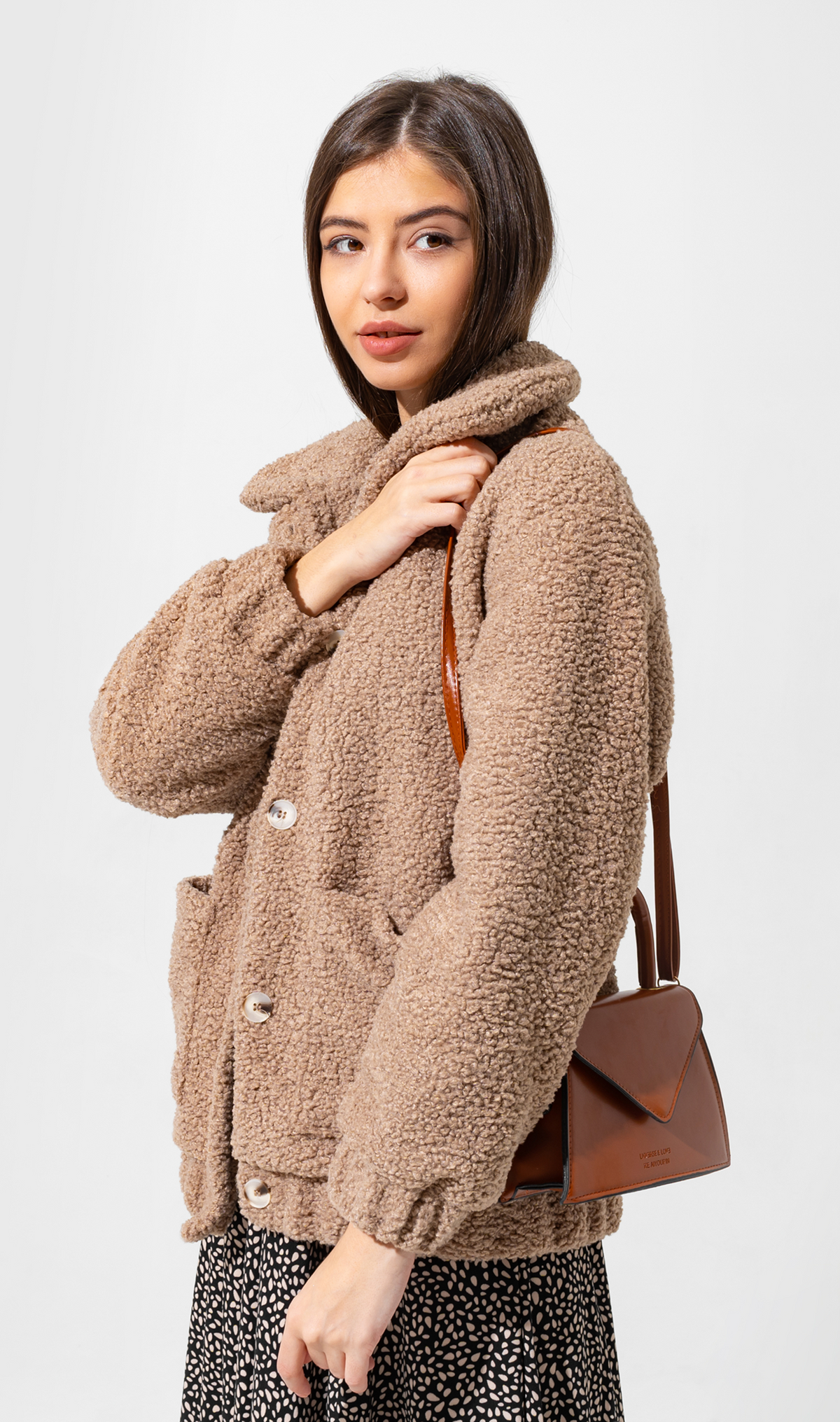 Model wearing a textured sherpa jacket with a high collar and button front