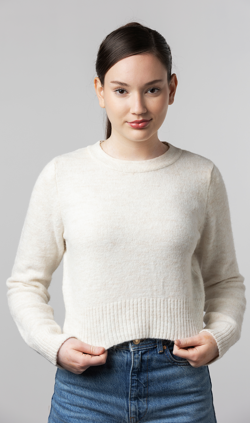 Model wearing a fine-gauge crewneck sweater with a relaxed fit