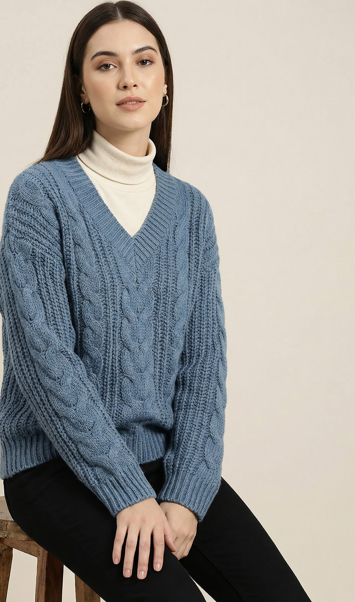 Model wearing a textured cable-knit V-neck sweater with a relaxed fit