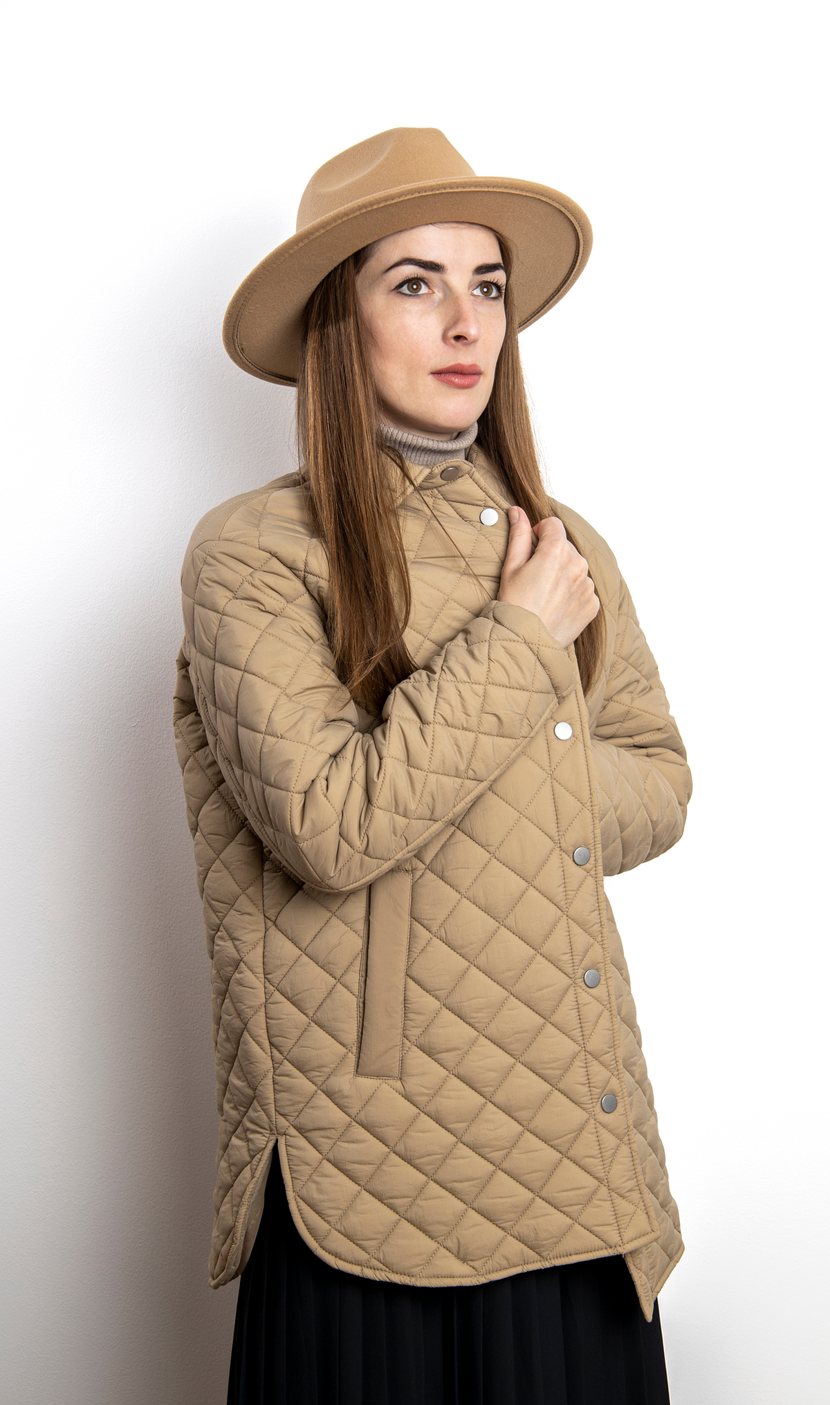 Diamond quilted jacket with raised neckline, snap-button front, and curved hem