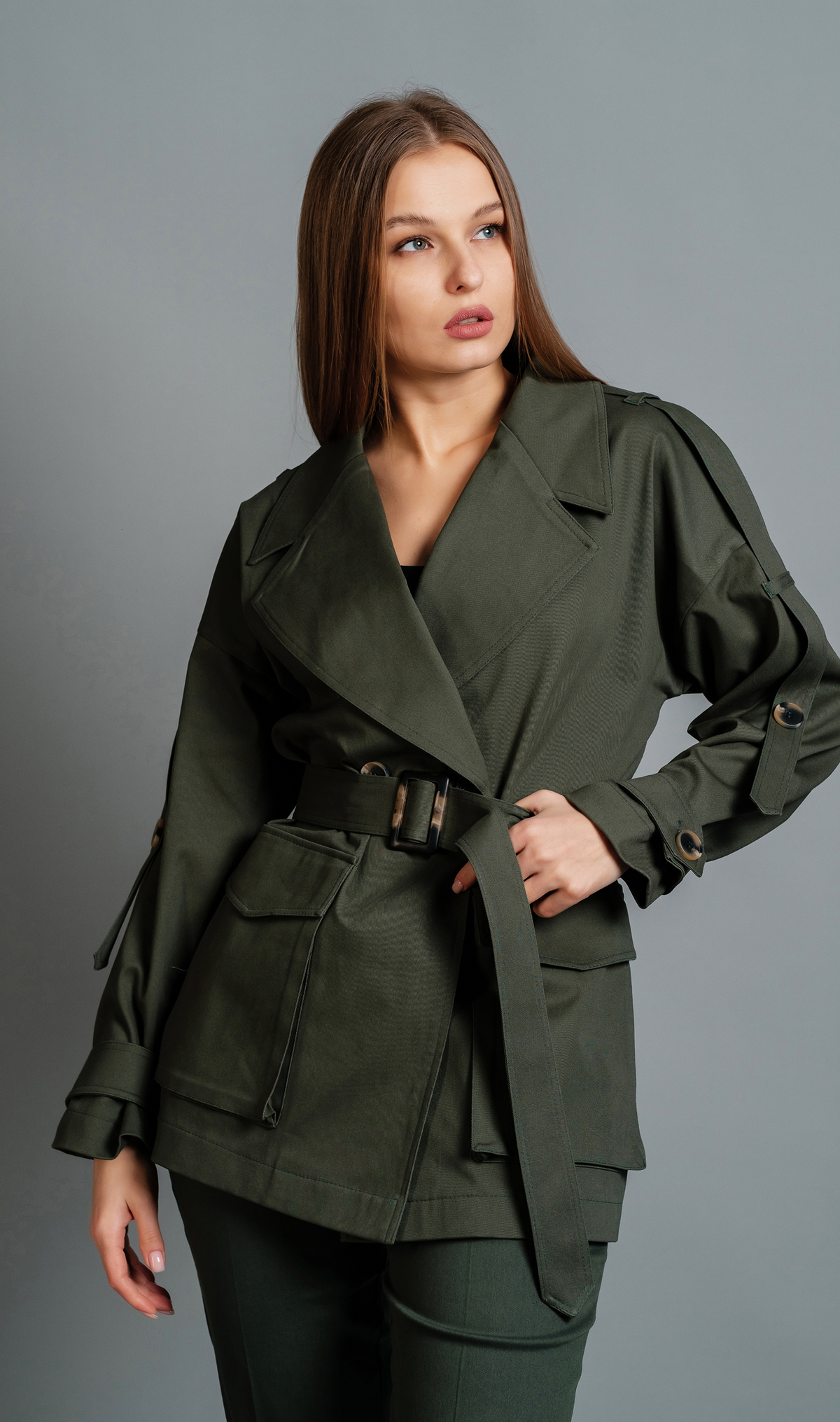 Belted utility jacket with wide lapels, adjustable waist belt, roomy patch pockets, and structured silhouette