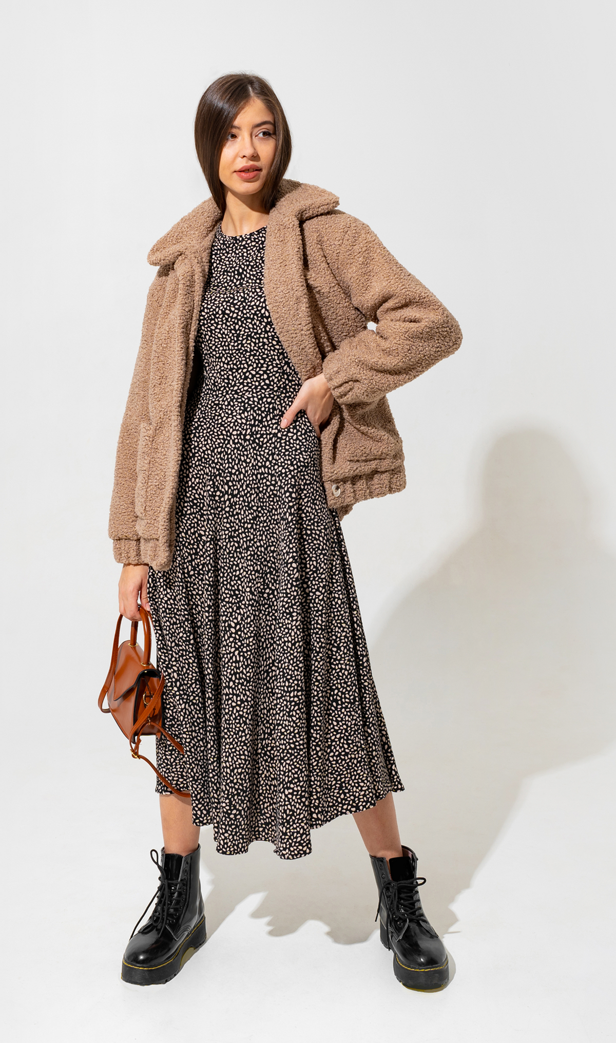 Model wearing a cozy textured sherpa jacket layered over a dress