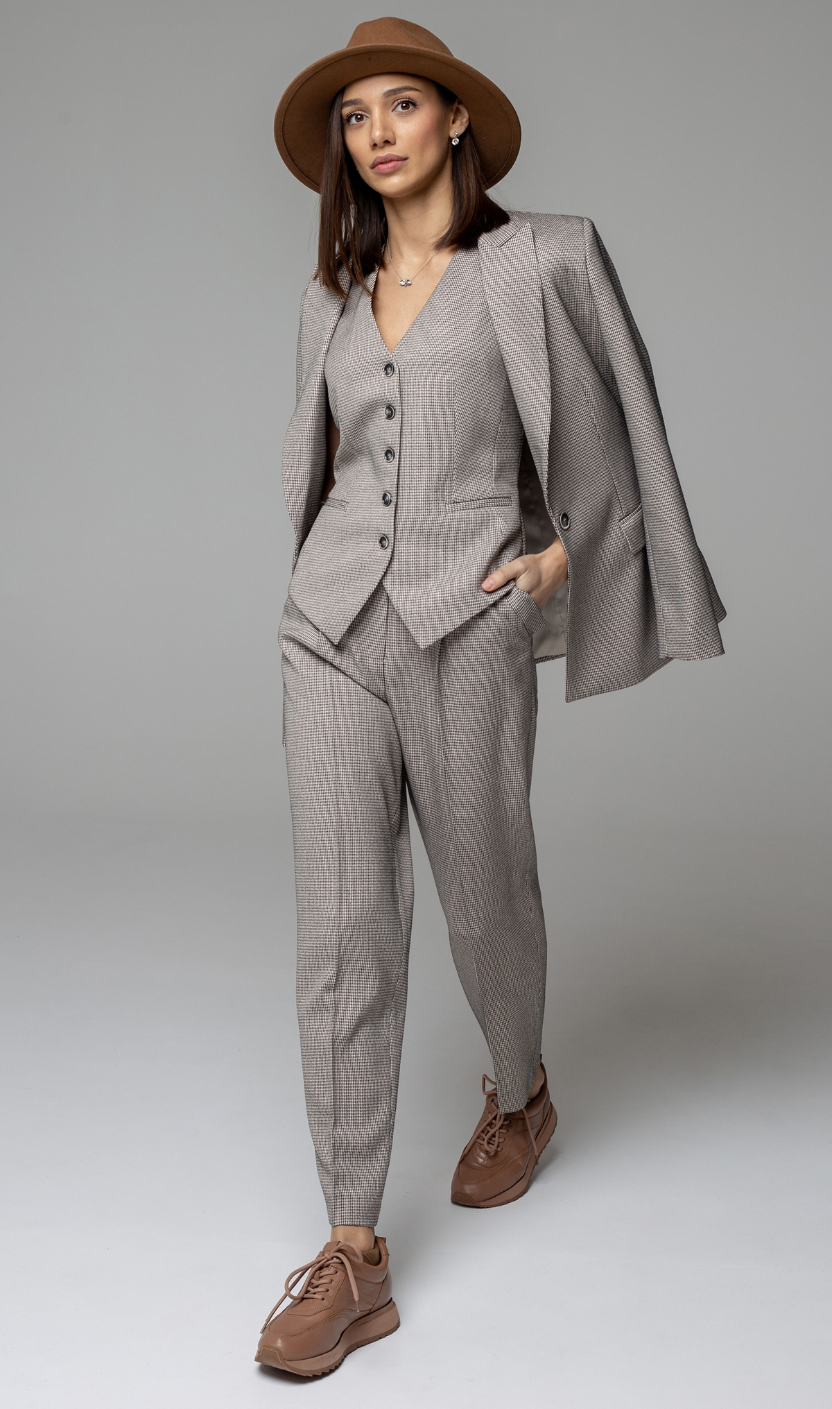 Model wearing a modern tailored suit with a vest, jacket, and coordinating trousers